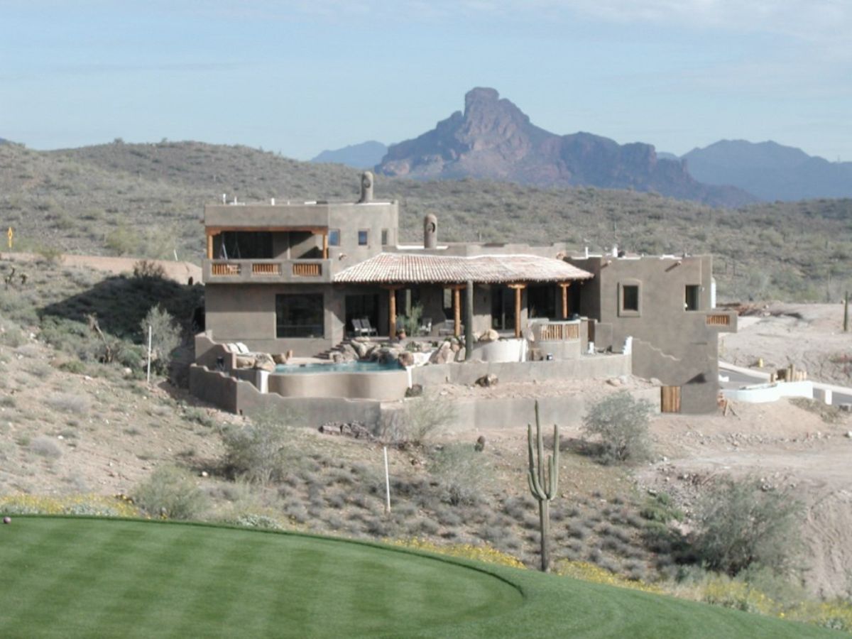 Southwestern luxury desert home with pool and patio by golf green, saguaro cactus and mountain view